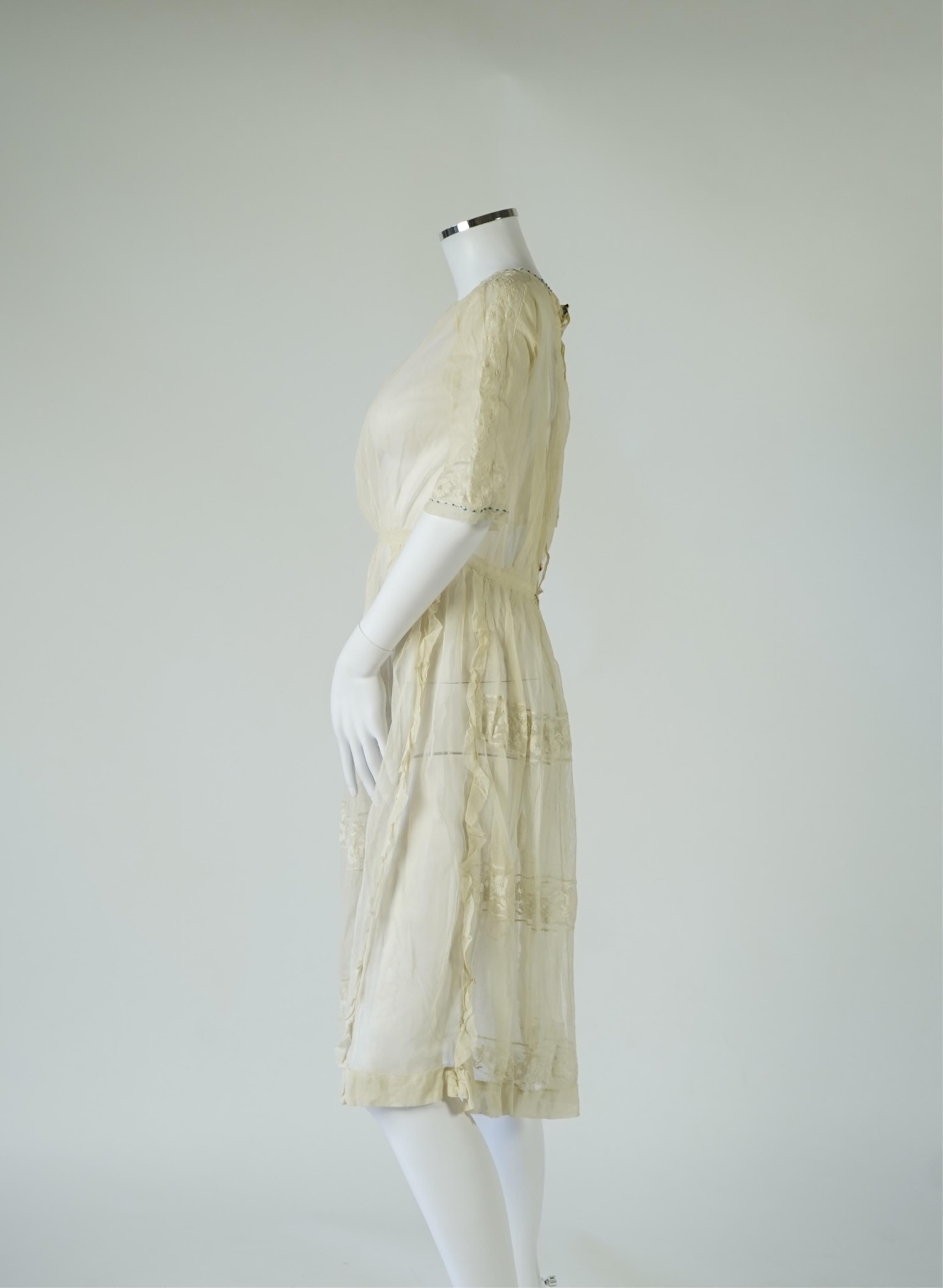 An early 20’s cream net ladies summer dress and net petticoat, designed with a lace inset front skirt, yolk and sleeves.103cm long. Condition - both need re-laundering and some seams tidying.